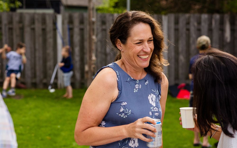 Jenny Peterson laughing with neighbors at a backyard gathering